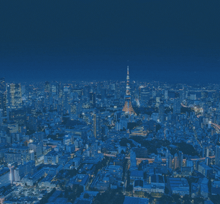 Aerial night view of Tokyo skyline with the iconic Tokyo Tower lit orange at the center.
