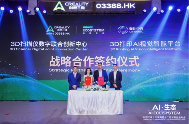 Four executives sign documents at a signing ceremony on a stage with a blue backdrop displaying Creality logos and bilingual project text (Strategic Cooperation Signing Ceremony).